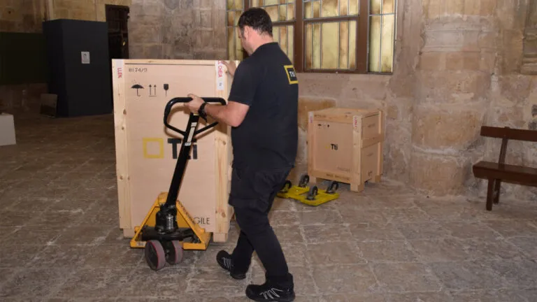 Un hombre transportando cajas en la Catedral de Palencia