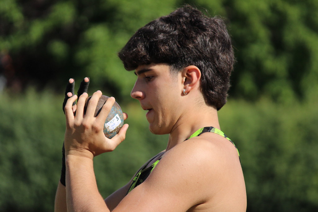 Atleta preparándose para lanzar una bola de peso en la competición