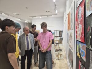Estudiantes observando trabajos de arte en la exposición de fin de curso