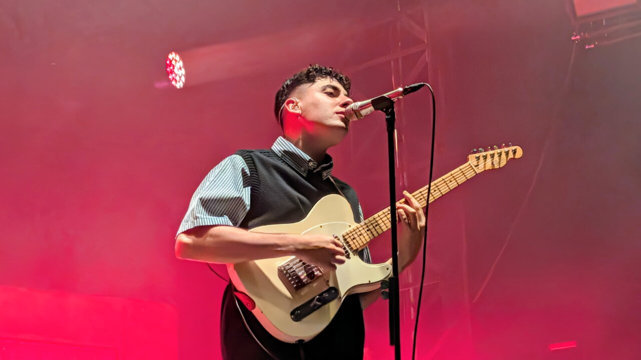 Músico actuando en el festival Palencia Sonora con guitarra y micrófono