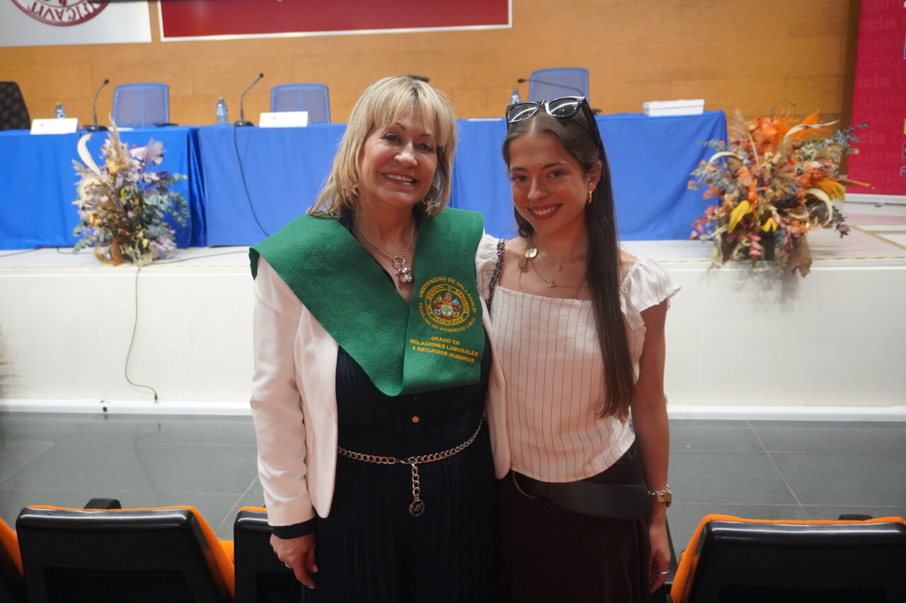 Dos mujeres sonrientes en ceremonia de graduación en Palencia