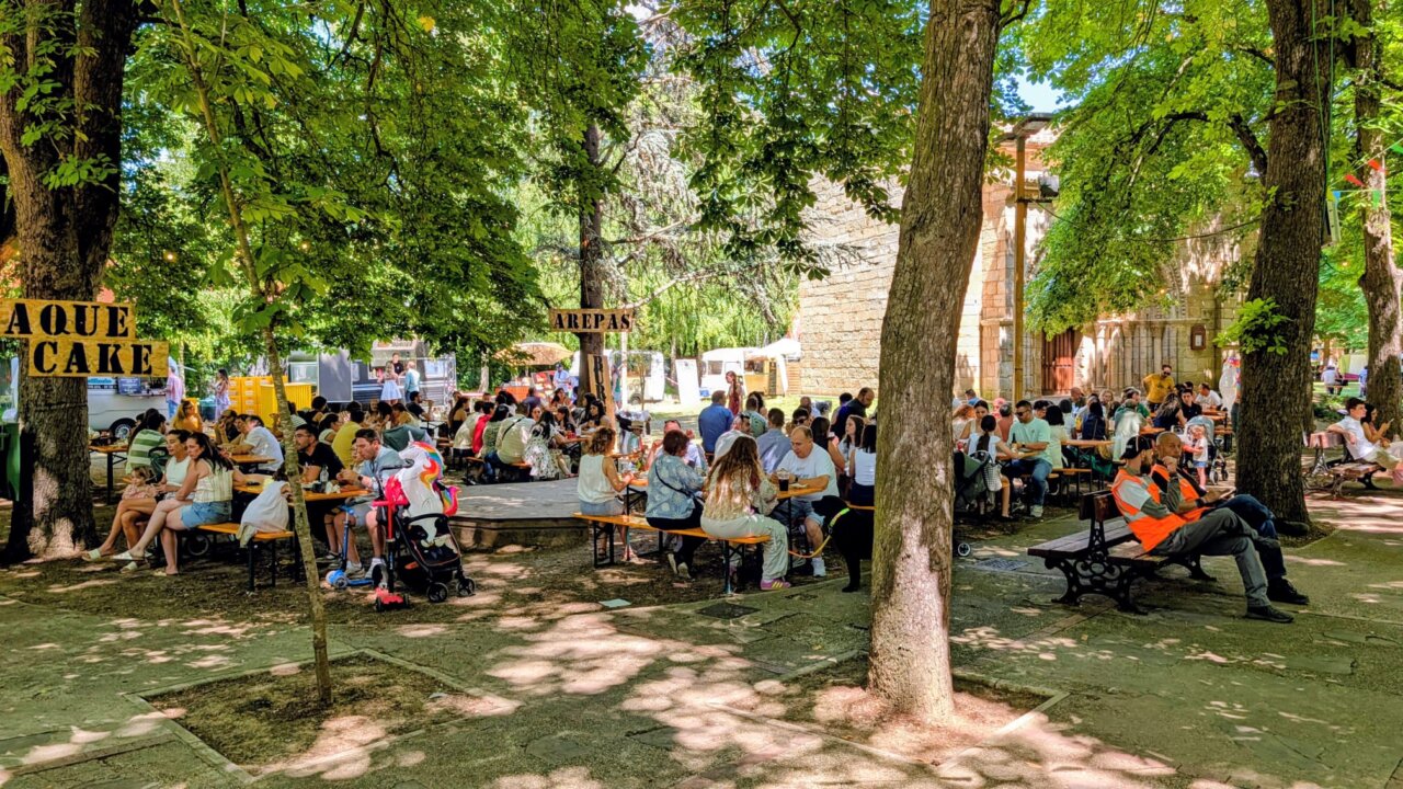 Gente disfrutando de la Feria Chica en Palencia con food trucks y mesas al aire libre.