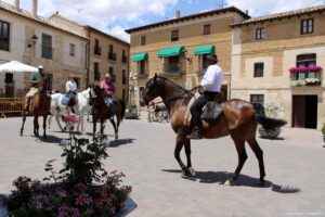 Jinetes montando a caballo en la plaza de Astudillo durante el aniversario