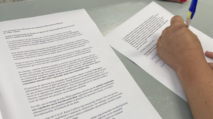 Persona firmando documentos para el nuevo colegio de Dueñas