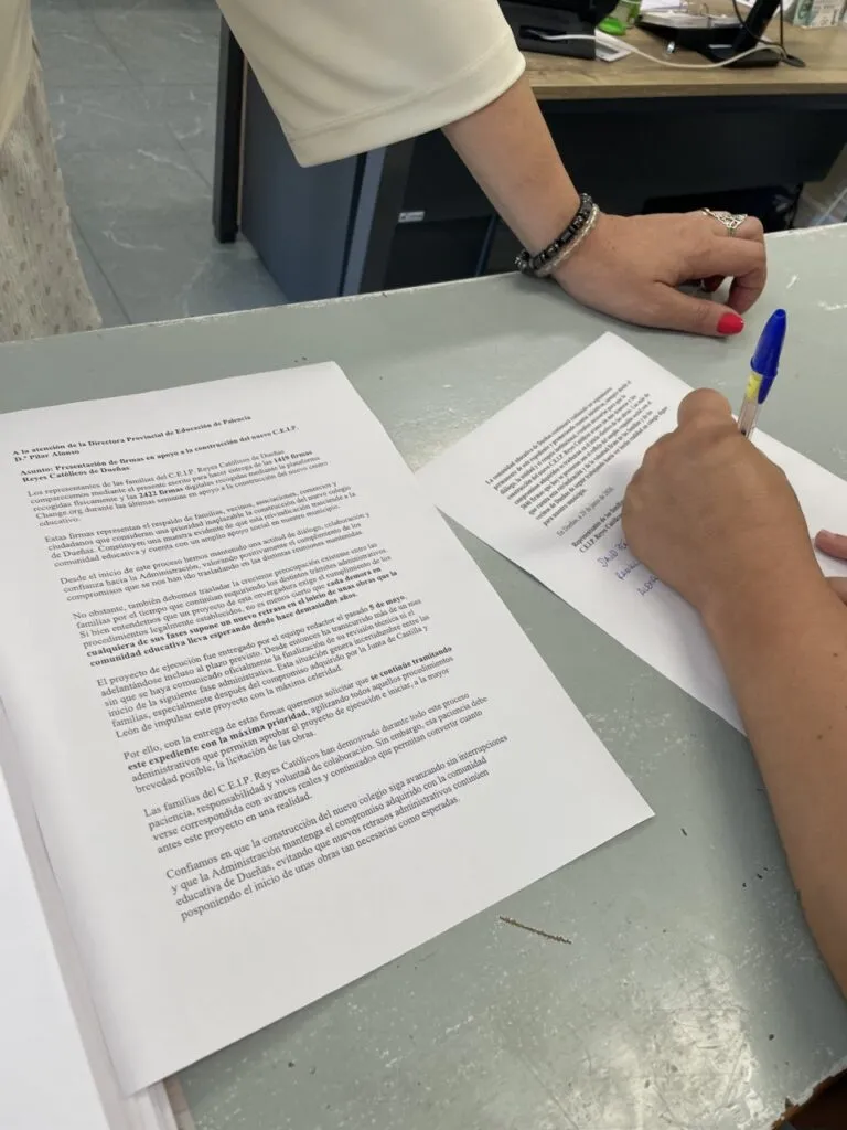 Persona firmando documentos para el nuevo colegio de Dueñas