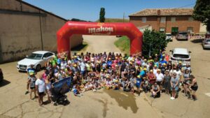 Participantes de la IV Marcha Solidaria Cembrero bajo un arco inflable