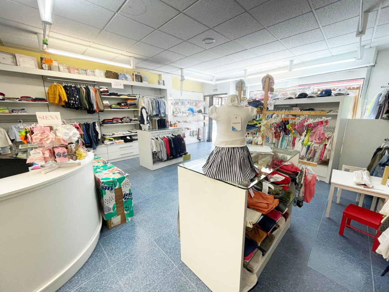 Interior de la tienda Modas Eva con ropa infantil y accesorios