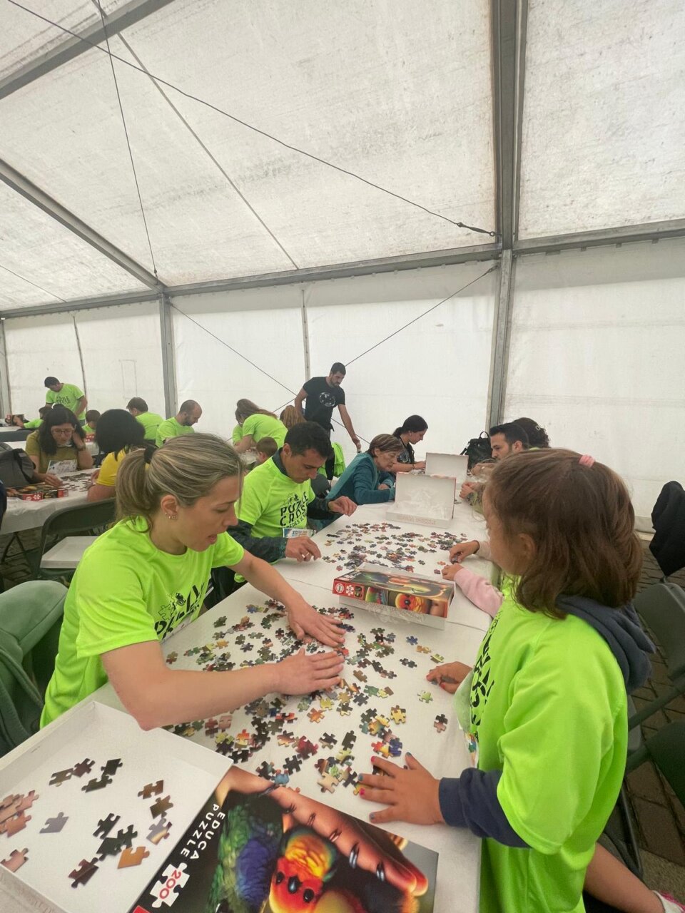 Participantes del XI Puzzle Cross en Paredes de Nava montando un rompecabezas.
