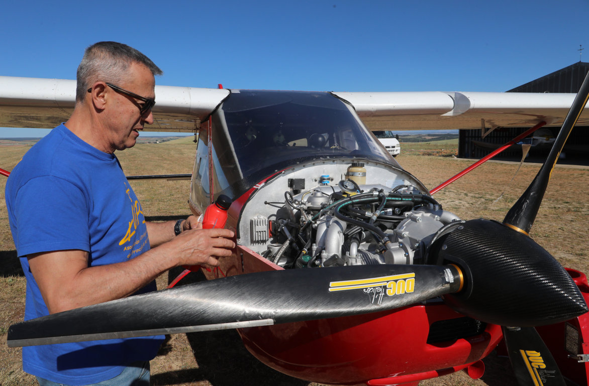 Técnico revisando el motor de un ultraligero en el aeródromo de Herrera de Pisuerga