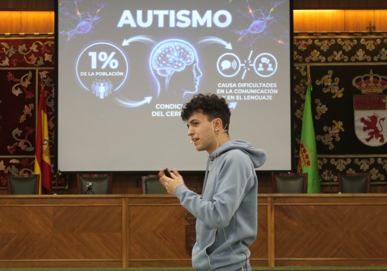 Joven hablando sobre autismo en un evento educativo
