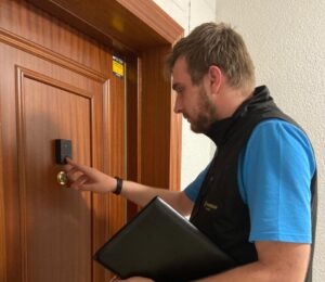 Asesor de seguridad revisando un sistema de alarma en una puerta