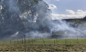 Bomberos utilizando aspersores para controlar un incendio en la finca de Viñalta
