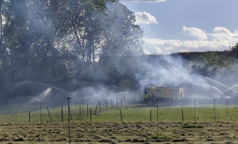 Bomberos utilizando aspersores para controlar un incendio en la finca de Viñalta