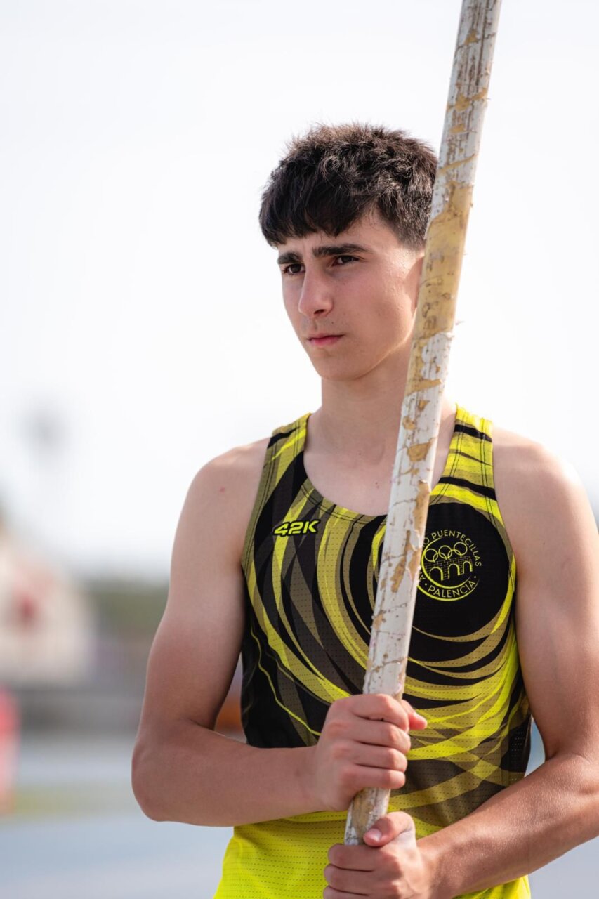 Atleta sosteniendo una pértiga en un evento de atletismo