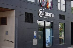 Fachada de la Cámara de Comercio de Palencia con banderas