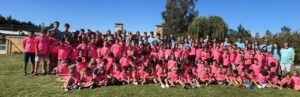 Grupo de niños y adultos en campamento urbano con camisetas rosas