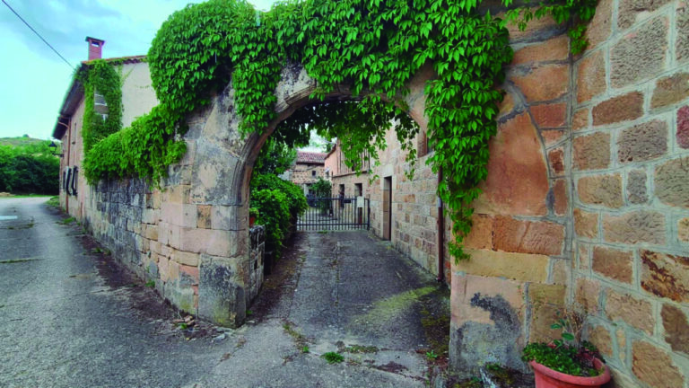 Entrada a un pueblo con vegetación y arquitectura tradicional