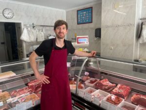 Carnicería El Brezo con productos cárnicos frescos y propietario
