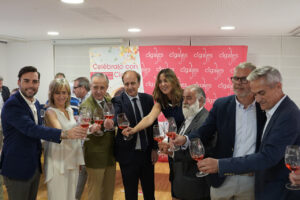 Grupo de profesionales brindando con copas de vino rosado en evento de cata