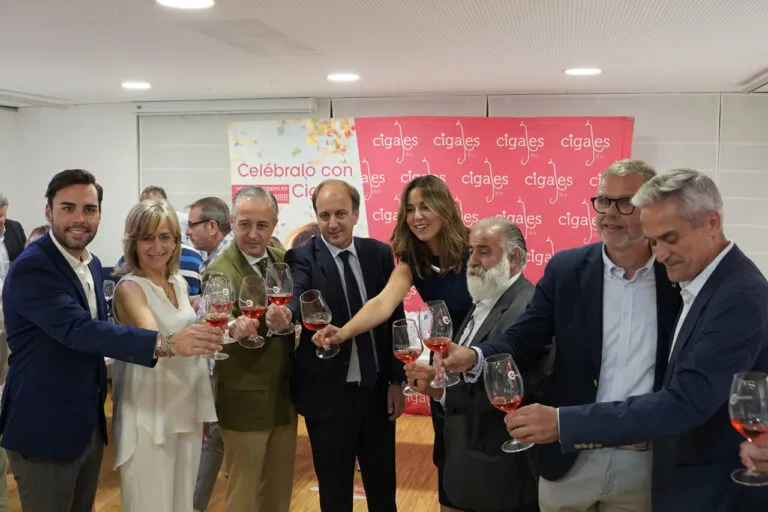 Grupo de profesionales brindando con copas de vino rosado en evento de cata