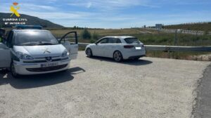 Vehículo de la Guardia Civil junto a un coche detenido en la carretera