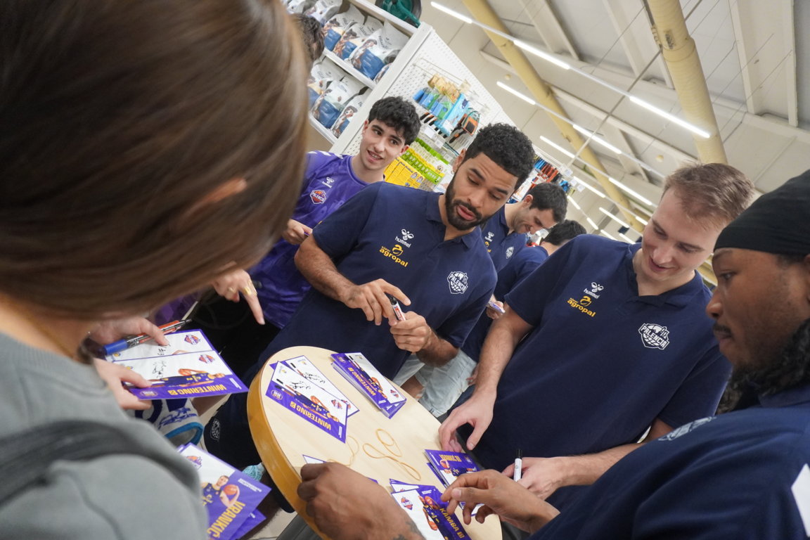 Jugadores de baloncesto firmando autógrafos en un evento