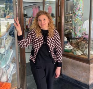 Mujer de pie en la entrada de una tienda de moda en Aguilar de Campoo