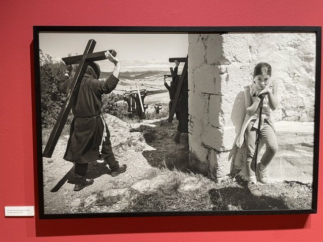 Fotografía en blanco y negro de una niña y un penitente con cruces