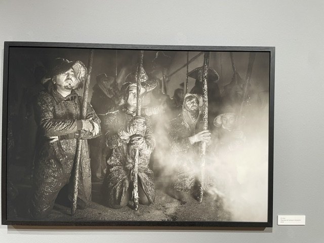 Fotografía en blanco y negro de hombres con varas en una exposición