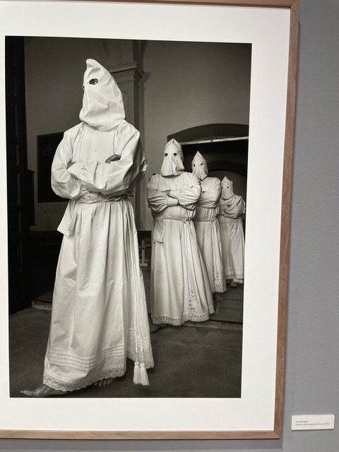 Fotografía en blanco y negro de personas con vestimenta tradicional en una exposición
