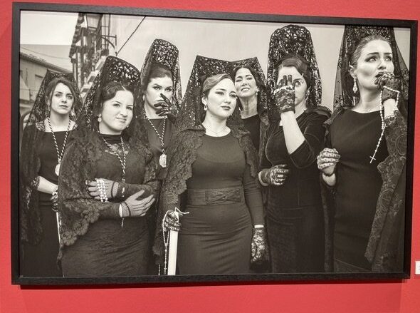 Fotografía en blanco y negro de mujeres con mantillas en una exposición