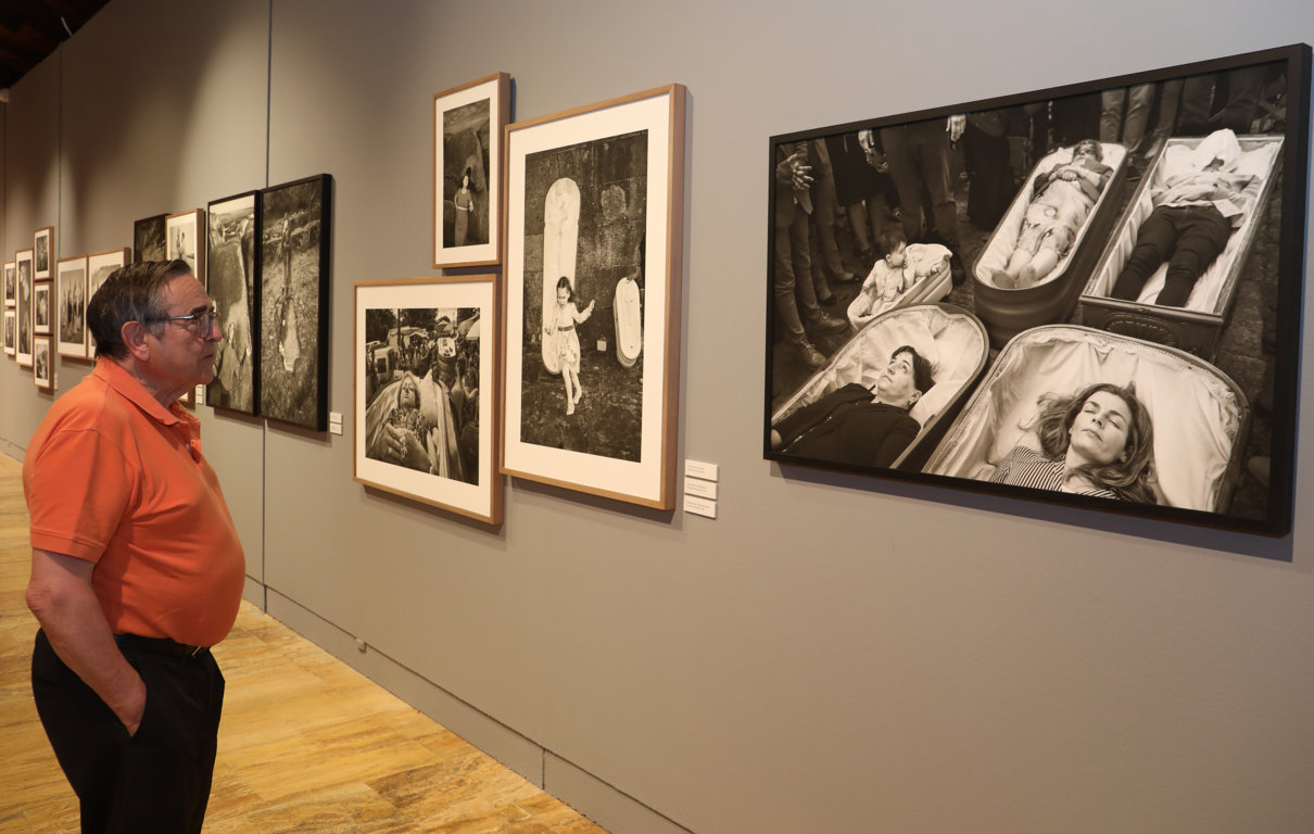 Persona observando fotografías en la exposición 'Hispania Sacra' en Palencia
