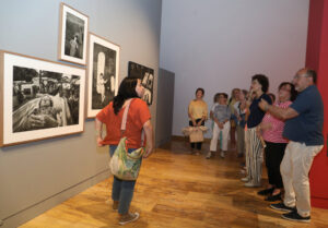 Visitantes observan fotografías en la exposición 'Hispania Sacra' en Palencia.