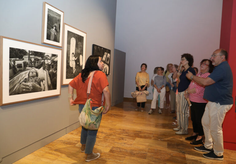 Visitantes observan fotografías en la exposición 'Hispania Sacra' en Palencia.