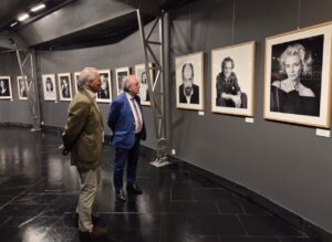 Visitantes observando retratos en la exposición Pallantiaphoto en el Museo de Palencia