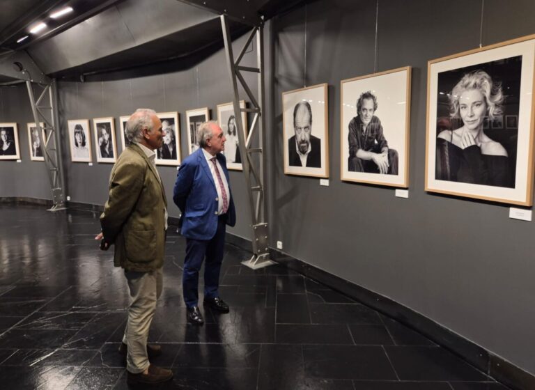 Visitantes observando retratos en la exposición Pallantiaphoto en el Museo de Palencia