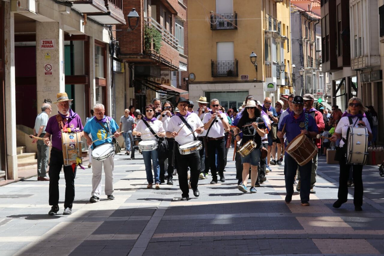 Desfile musical durante la Feria Chica en Palencia con participantes tocando instrumentos.