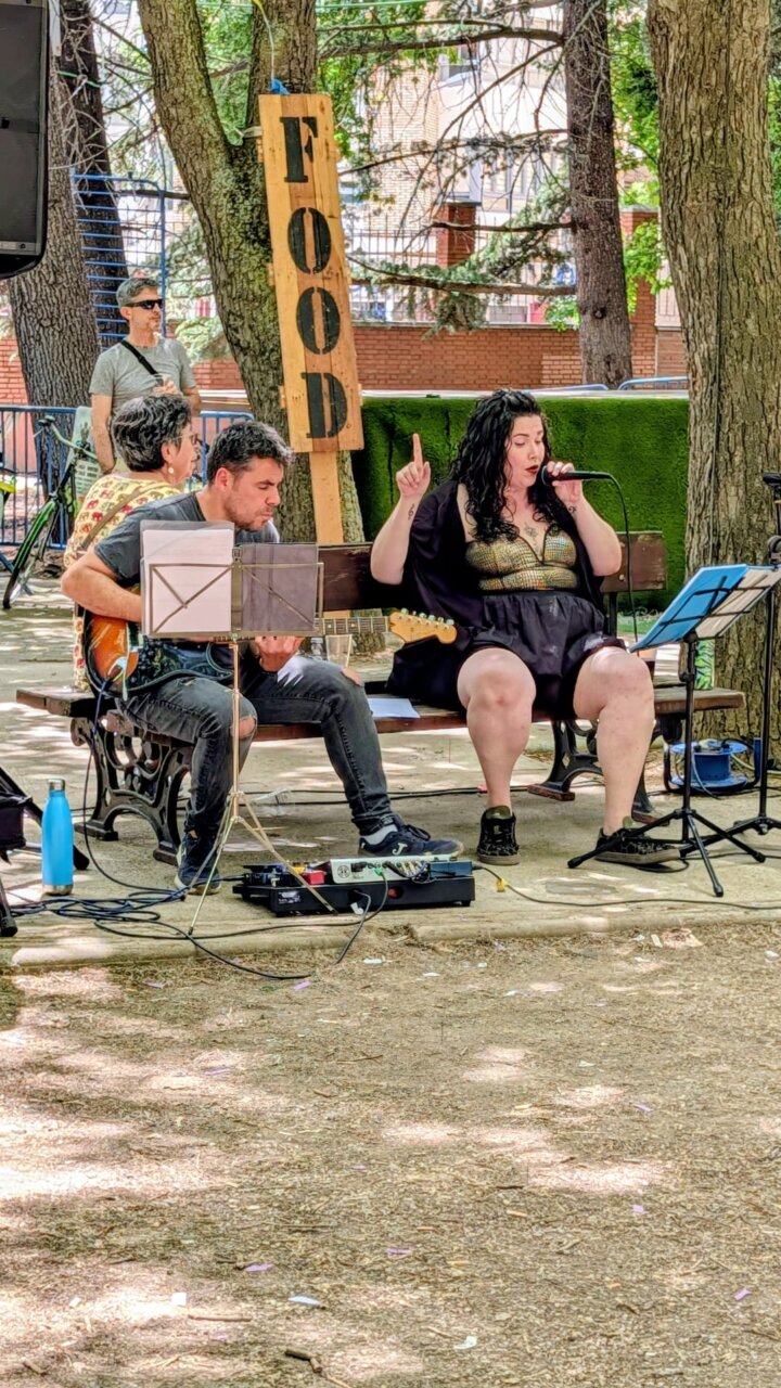 Músicos actuando en la Feria Chica de Palencia con un cartel de comida
