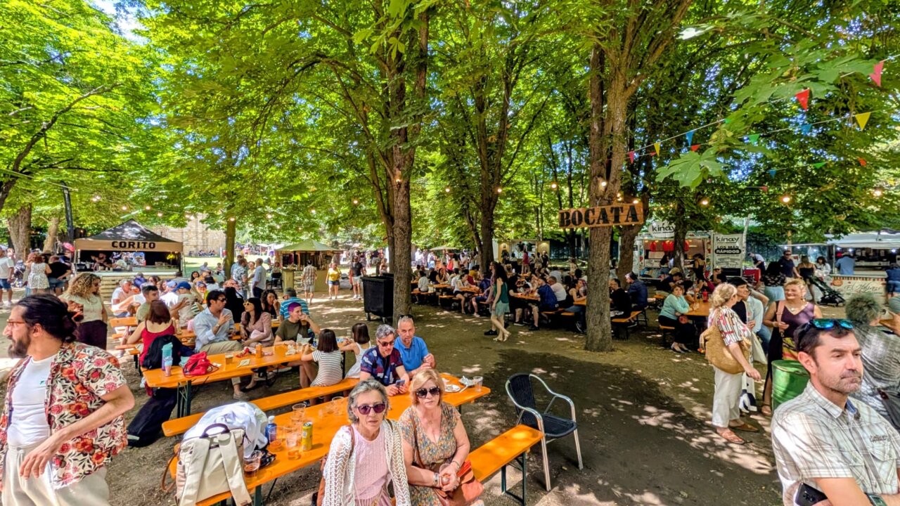 Gente disfrutando de la Feria Chica en Palencia con food trucks y mesas al aire libre.