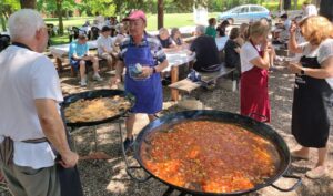 Participantes de la Fiesta del Socio de Amidecon cocinando paella al aire libre