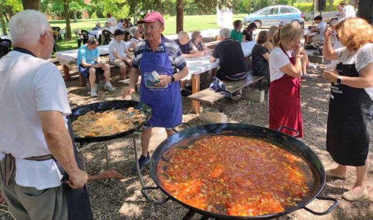 Participantes de la Fiesta del Socio de Amidecon cocinando paella al aire libre