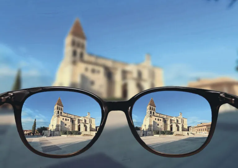 Gafas reflejando un edificio histórico en un entorno rural