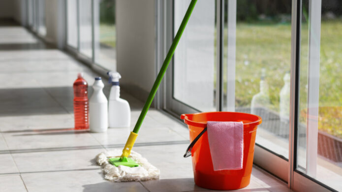 Herramientas de limpieza en un interior con un trapeador y productos