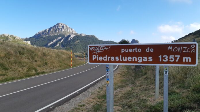 Señal del puerto de Piedrasluengas con montañas al fondo