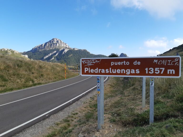 Señal del puerto de Piedrasluengas con montañas al fondo