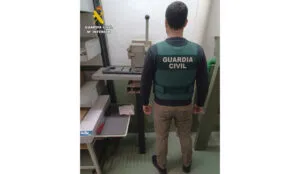 Agente de la Guardia Civil inspeccionando un taller de placas de matrícula