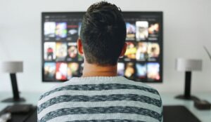 Hombre viendo una pantalla con contenido digital en un entorno moderno.