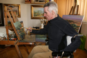 Pintor trabajando en su estudio con un caballete y pinceles