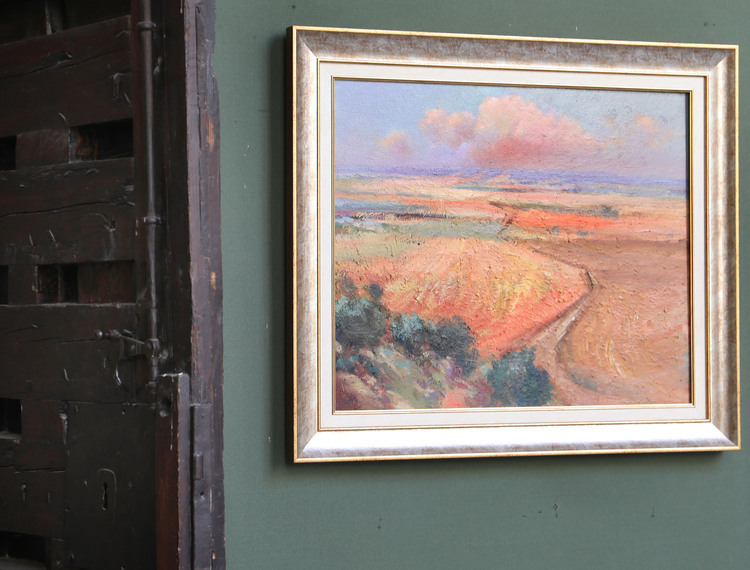 Pintura de paisaje enmarcada con tonos cálidos y nubes