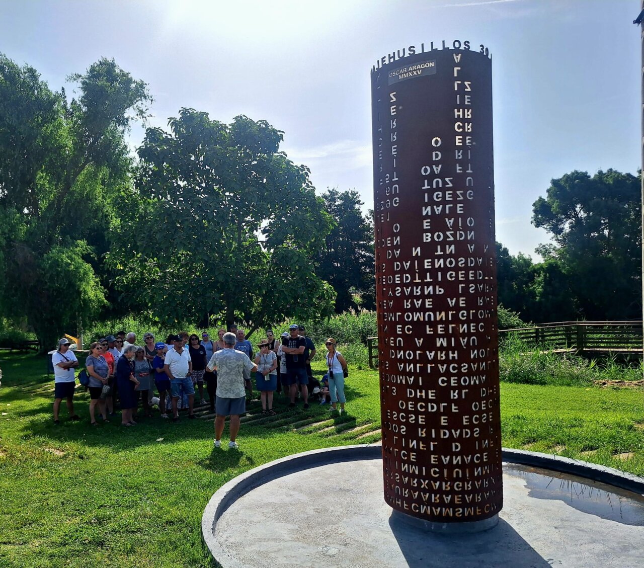 Grupo de caravanistas en el parque del río en Husillos junto al Monolito de la Memoria.